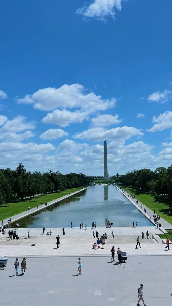 People walking near the Washington Monument and reflecting pool, suggesting US citizens abroad considering their tax obligations People walking near the Washington Monument and reflecting pool, suggesting US citizens abroad considering their tax obligations