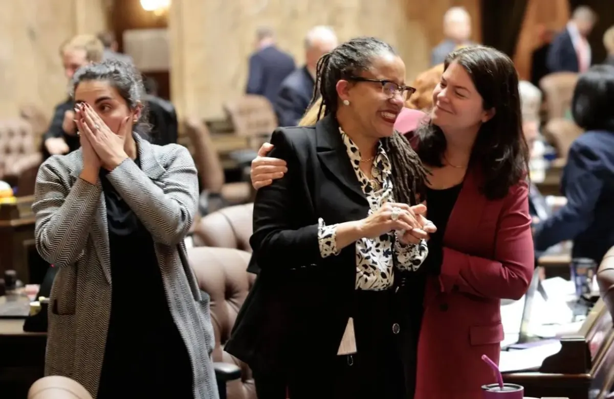 Three women smiling and interacting in an office-like social setting Three women smiling and interacting in an office-like social setting